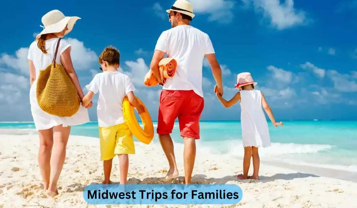 A family of four, dressed in summer attire, walks on a sandy beach towards the ocean. The adults carry beach bags and towels, while the children hold beach toys. The sky is clear and blue. Text at the bottom reads "Midwest Trips for Families.