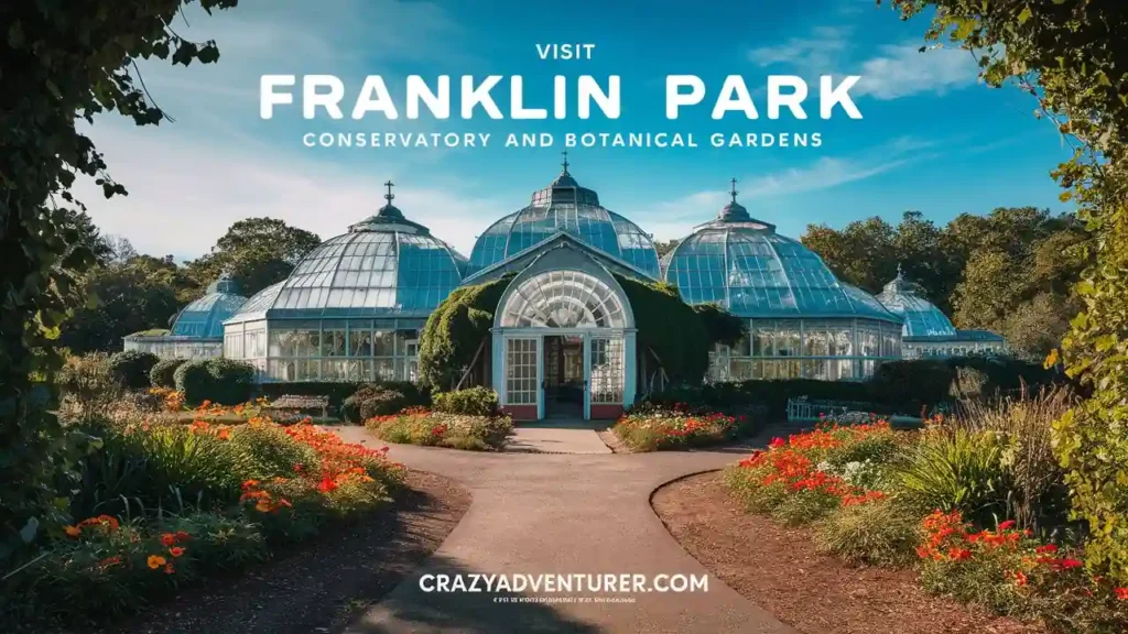 A well-maintained pathway leads to the entrance of a large, historic conservatory with glass domes and arches. Vibrant red and orange flowers with green foliage line the path. The text at the top reads, "Visit Franklin Park Conservatory and Botanical Gardens.
