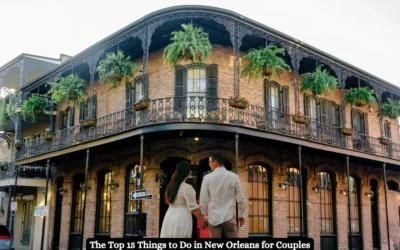 A couple stands in front of a historic New Orleans building with ornate ironwork balconies adorned with hanging plants. The building is two stories tall with large windows. Text at the bottom reads: The Top 15 Things to Do in New Orleans for Couples.