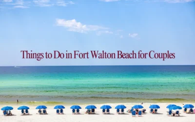 A scenic beach view with rows of blue umbrellas and chairs on white sand. The ocean shows shades of green and blue, and the text Things to Do in Fort Walton Beach for Couples is displayed over the sky.